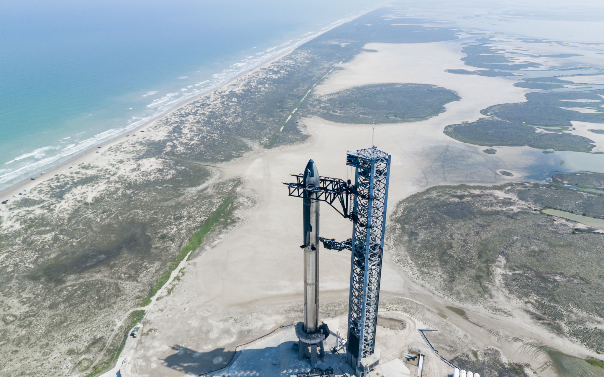 Aerial view of Starship, the launch tower and the South Texas coast, photographed by SpaceX